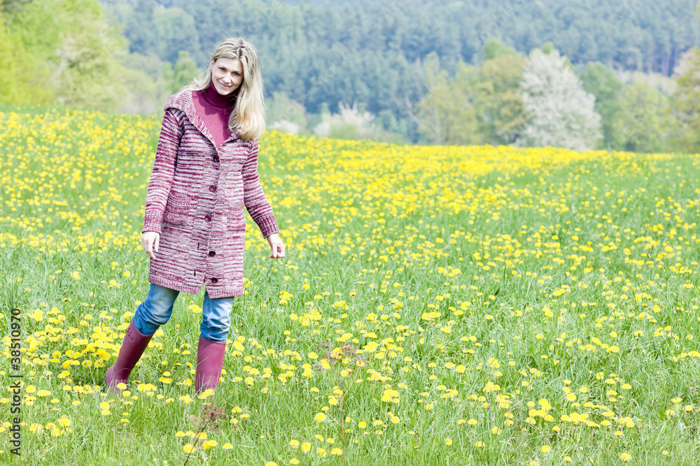 woman wearing rubber boots standing on spring meadow woman wearing rubber boots standing on spring meadow