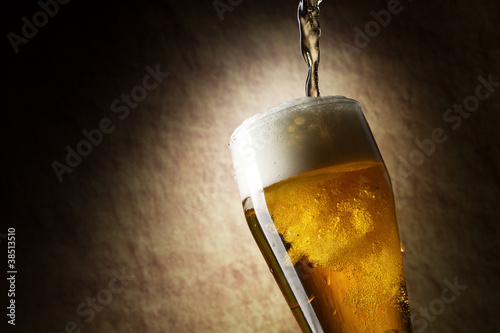 Beer into glass on a old stone
