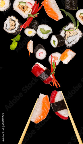 Sushi pices flying on black background