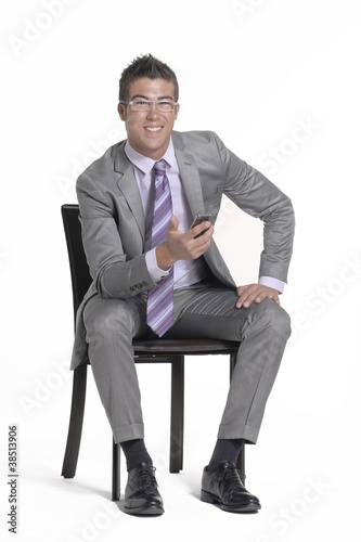 Hombre ejecutivo sentado con un teléfono celular. photo