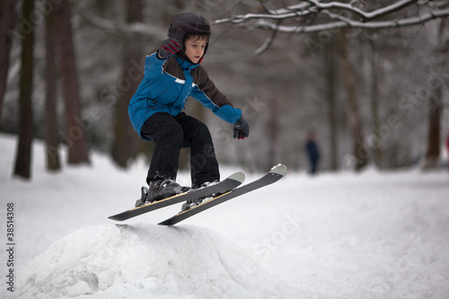 Little boy skier on ski-jump