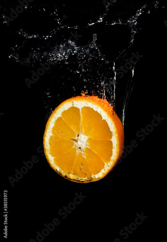 oranje slice falling in water with splash