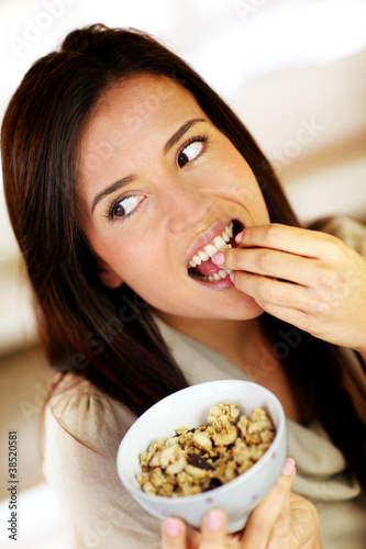 Beautiful brunette eating cereals in the morning