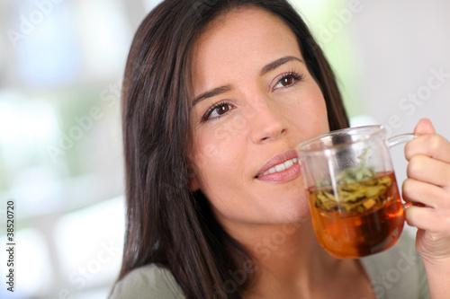 Portrait of young woman drinking herbal infusion