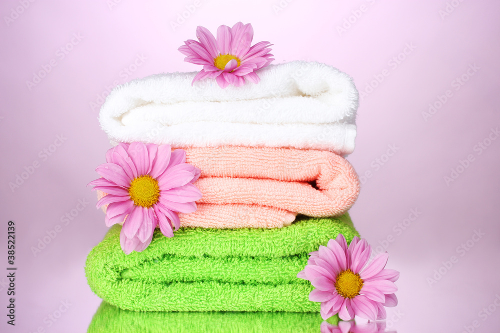 towels and beautiful flowers on pink background towels and beautiful flowers on pink background
