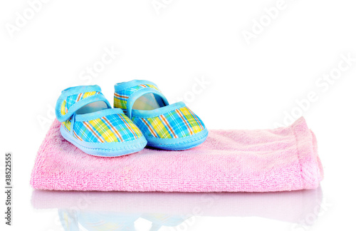 Blue baby booties on pink towel isolated on white