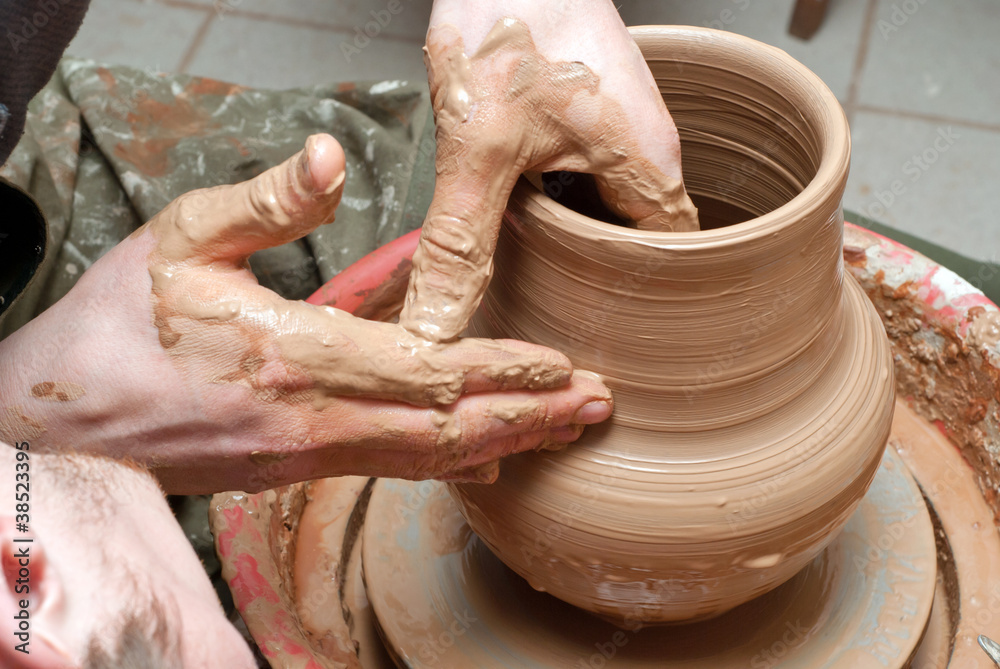 hands of a potter, creating an earthen jar on the circle