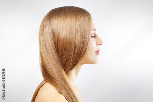 Girl with beautiful straight hair on gray