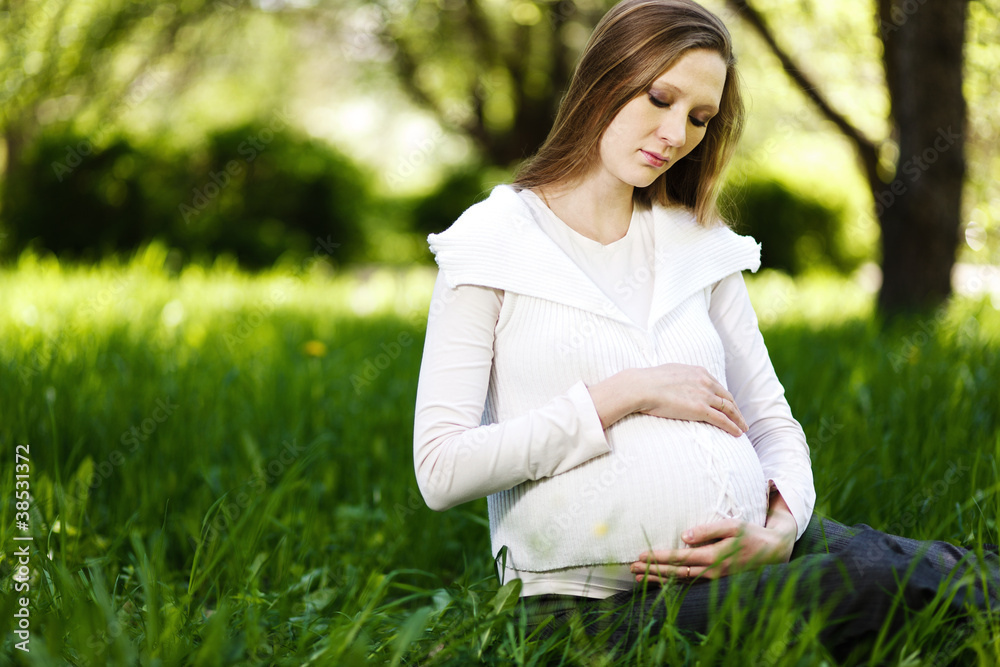 Beautiful pregnant woman relaxing in the park Beautiful pregnant woman relaxing in the park