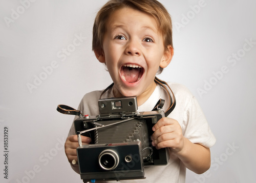 Happy photographer boy ,child ,kid taking a picture with a Polaroid style instant camera photo