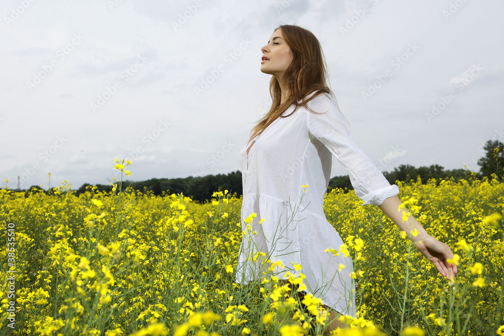 Fototapeta premium brunette woman in a yellow flowers field