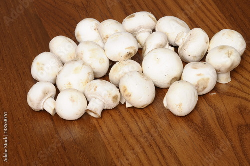 White freshs Paris mushrooms on wooden table for cooking.