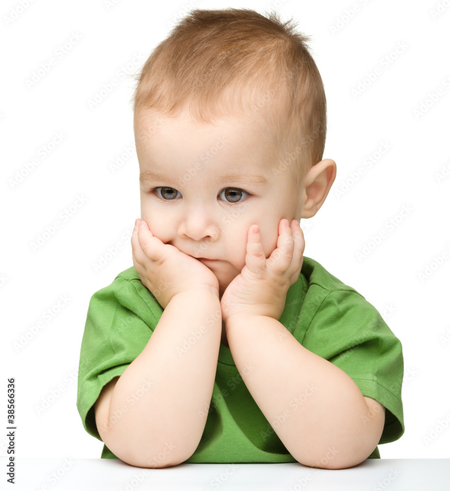 Pensive little boy support his head with hands Pensive little boy support his head with hands