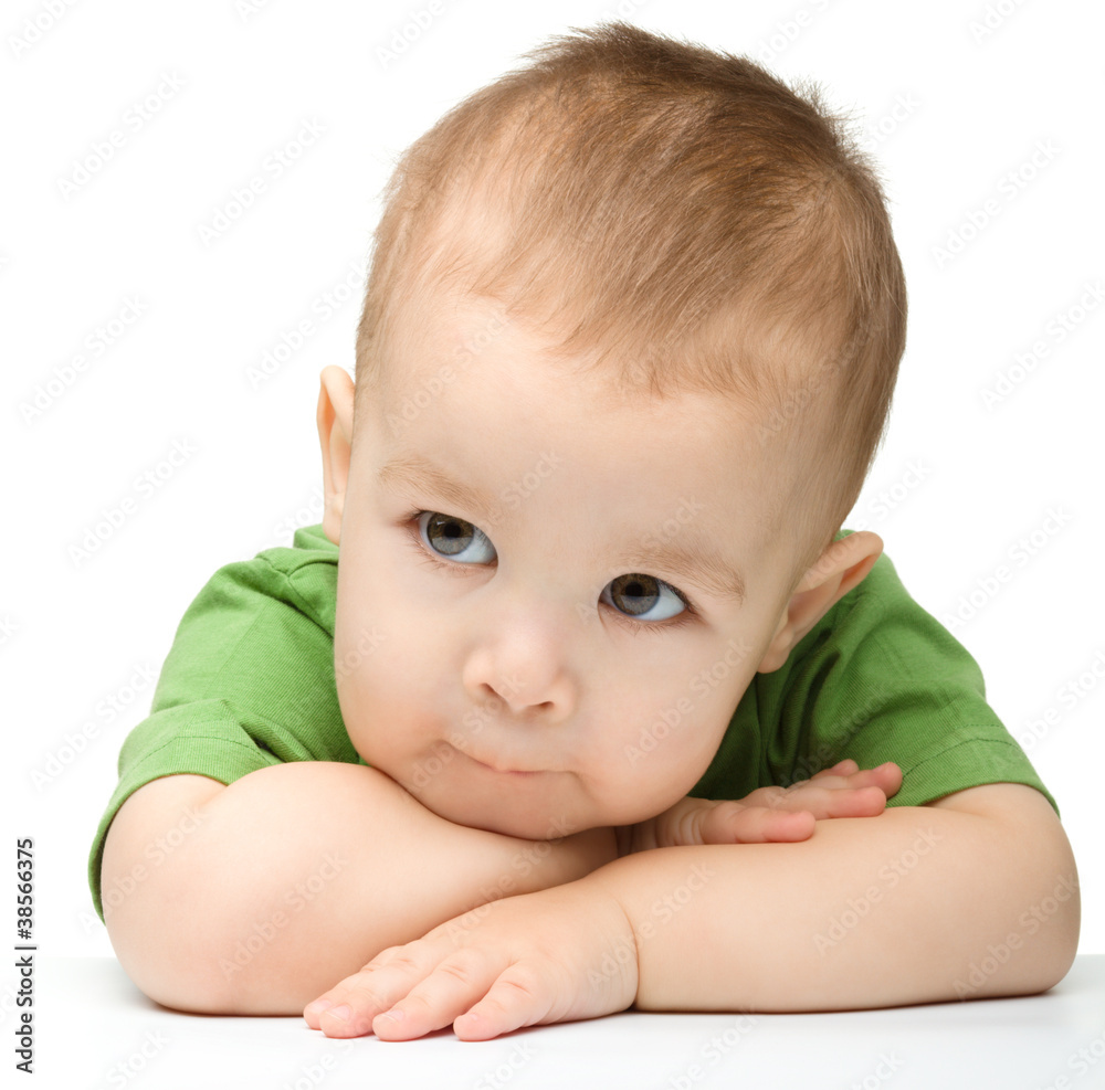 Pensive little boy support his head with hands