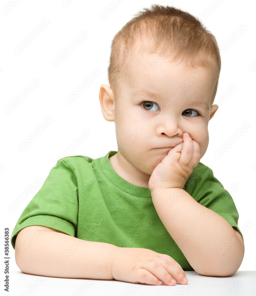 Pensive little boy support his head with hand Pensive little boy support his head with hand