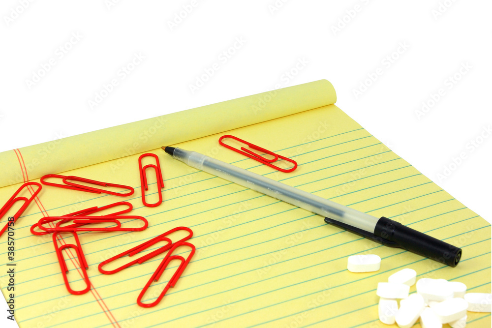 Yellow Legal Pad With Paperclips, Pen, And White Pills Yellow Legal Pad With Paperclips, Pen, And White Pills