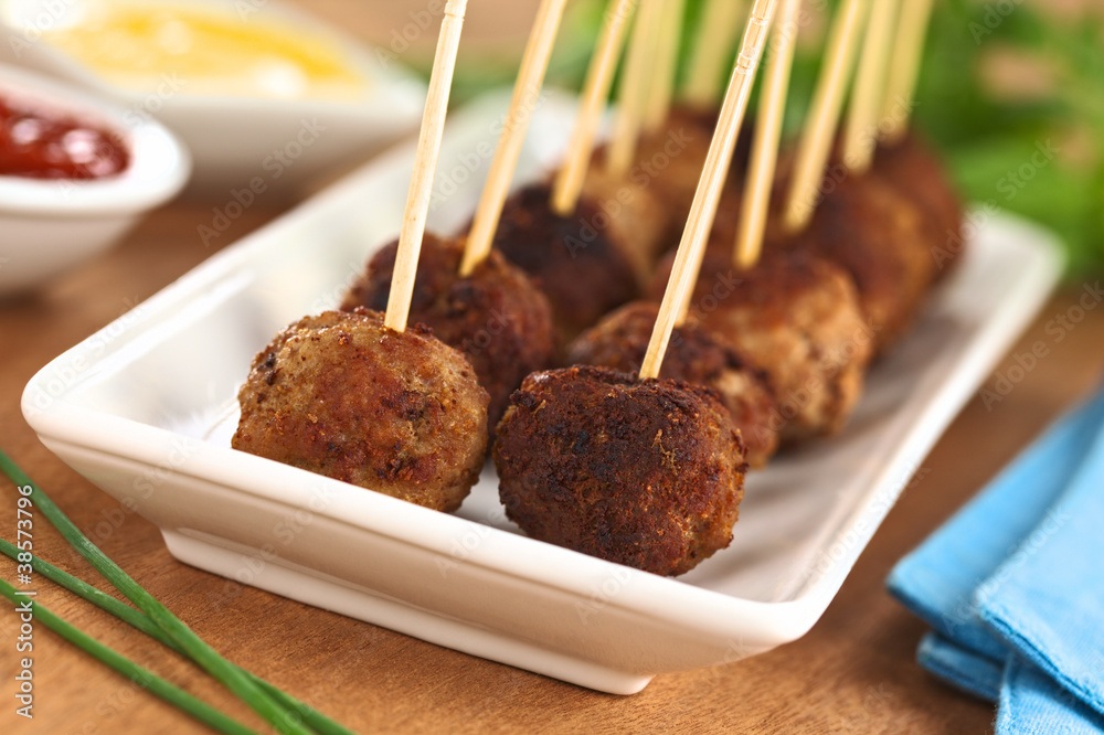 Meatball appetizers with toothpicks and sauces on the side Meatball appetizers with toothpicks and sauces on the side
