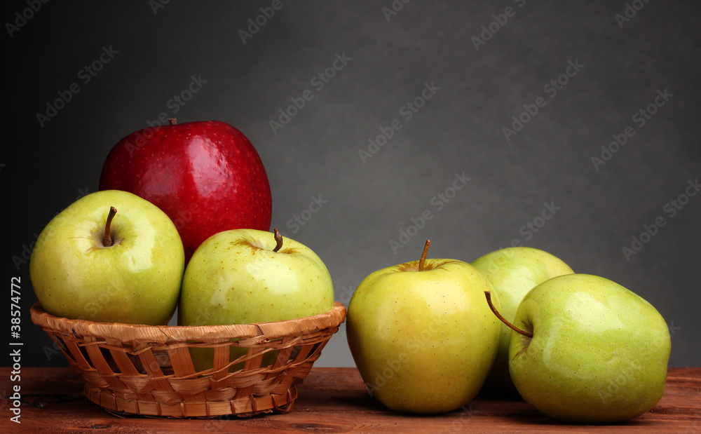 juicy sweet apples in basket on wooden table on gray background juicy sweet apples in basket on wooden table on gray background