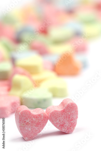 Little colorful candy hearts on white background. Shallow dof