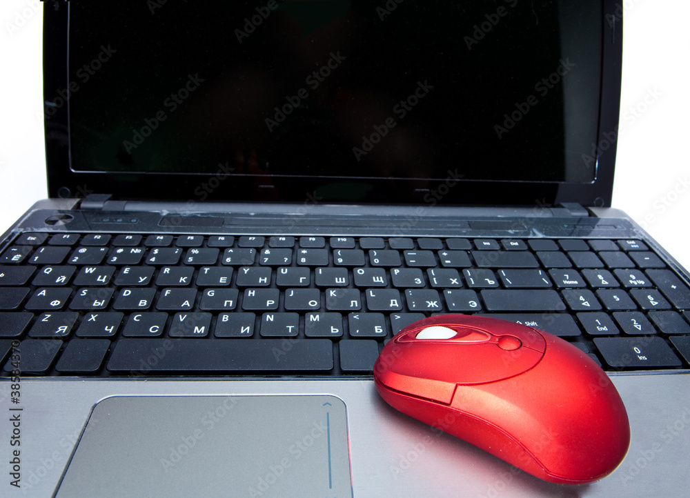 The red computer mouse on the black keyboard The red computer mouse on the black keyboard