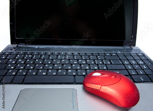 The red computer mouse on the black keyboard