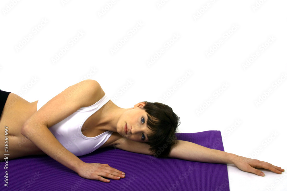 junge frau liegt entspannt auf einer yogamatte junge frau liegt entspannt auf einer yogamatte