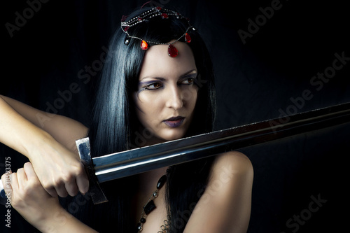 Young sexy woman warrior holding sword photo