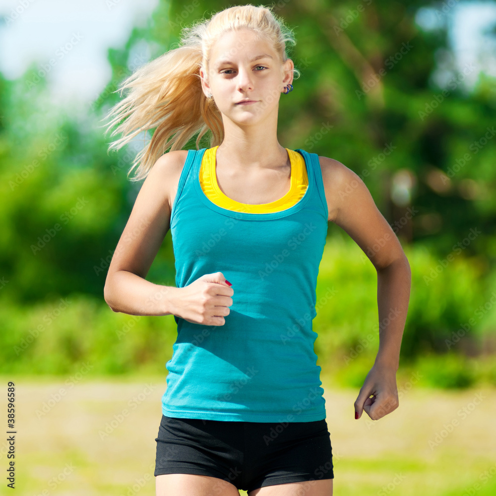 Young woman running in green park Young woman running in green park