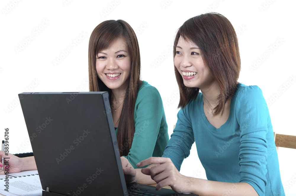 Two Asian female student studying and using computer Two Asian female student studying and using computer