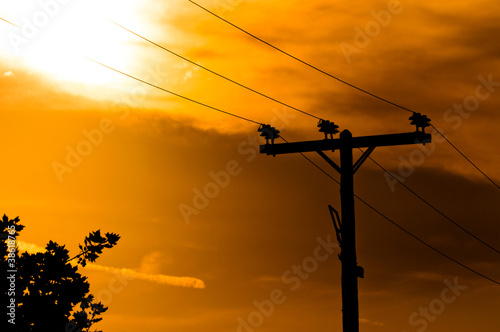 High voltage post against sky at dusk