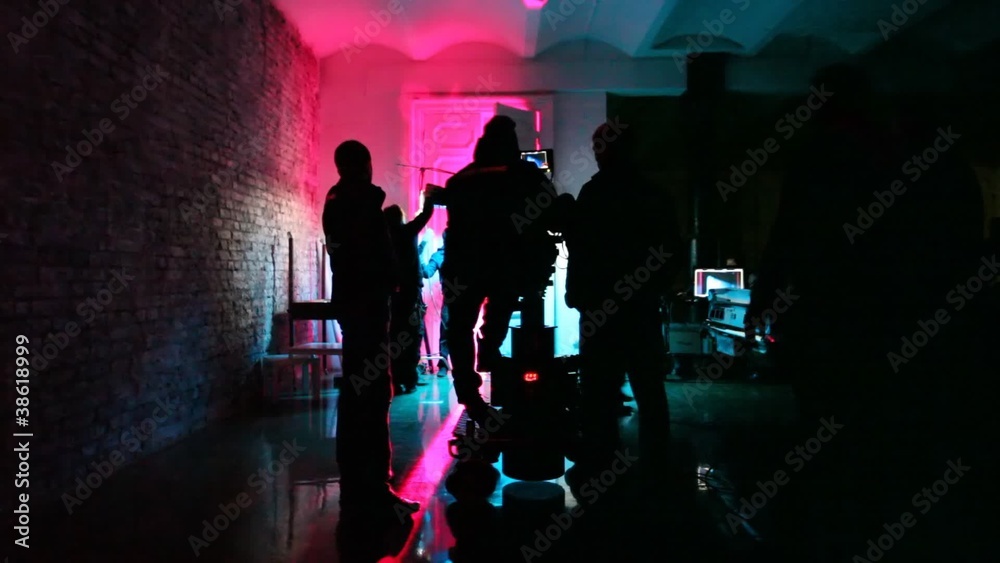 operator with videocamera and film crew in room prepare scenery