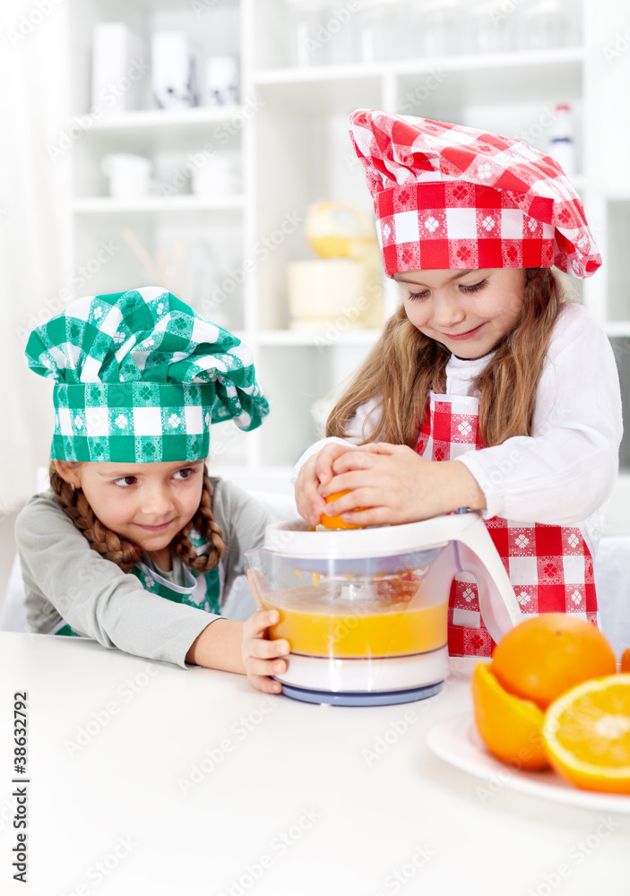 Little girls making fresh orange juice Little girls making fresh orange juice