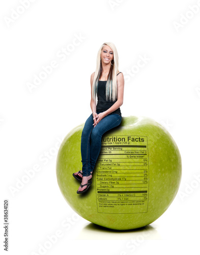 Woman Sitting on Red Delicious Apple with Nutrition Label photo