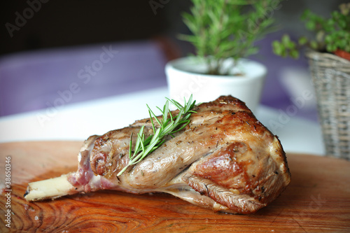 Roasted leg of lamb with rosemary on the cutting board