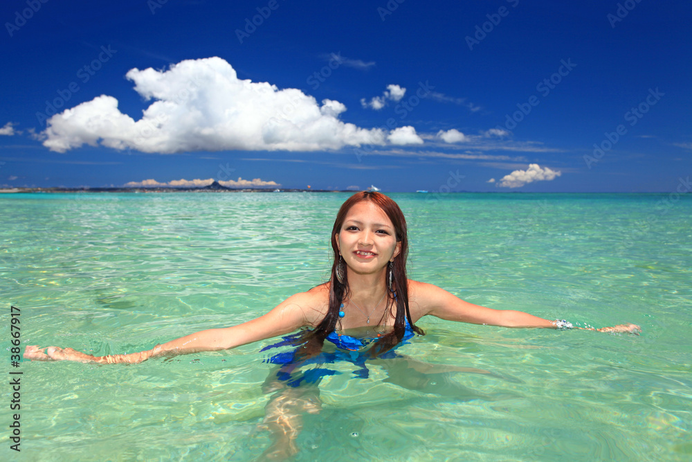 水納島の美しい海と海水浴を楽しむ女性