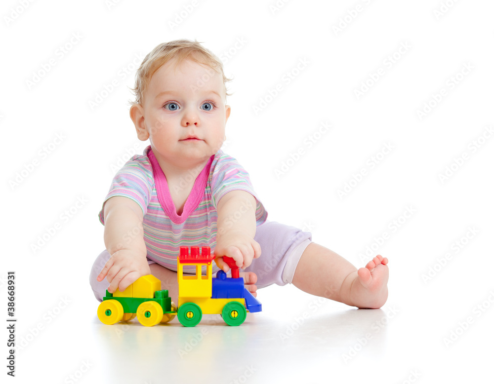 Cute little boy is playing with colorful train isolated on white Cute little boy is playing with colorful train isolated on white