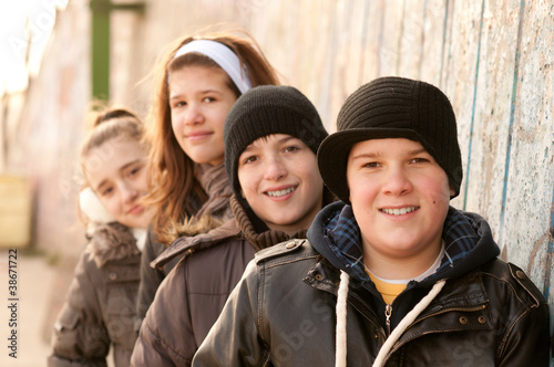 Group of smiling teenage friends posing outside