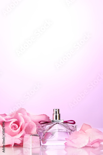 Perfume bottle and pink rose on pink