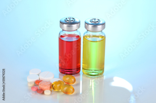 Tablets and ampoules on blue background