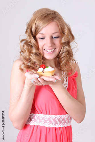 Happy woman with little cake in hand