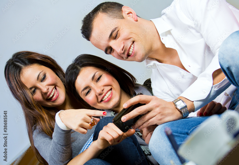 Obraz premium three friends having fun with a mobile phone