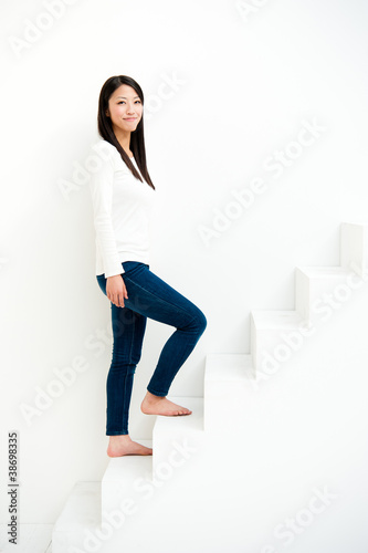 attractive asian woman on stairs in the white room