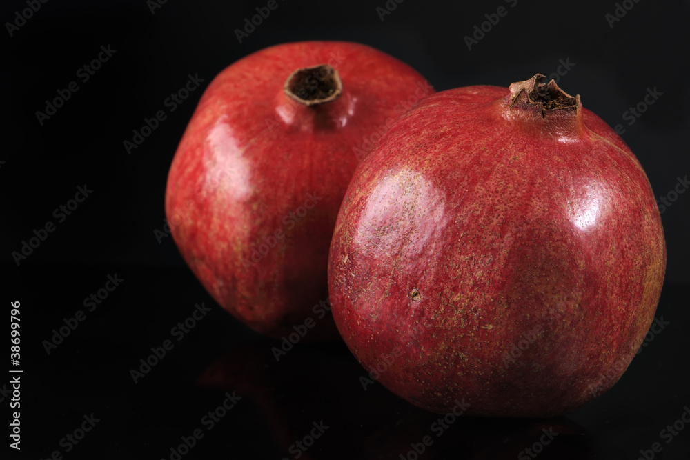 Two ripe pomegranates on black background Two ripe pomegranates on black background