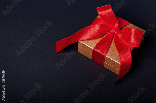 Box, bow and ribbon on dark background