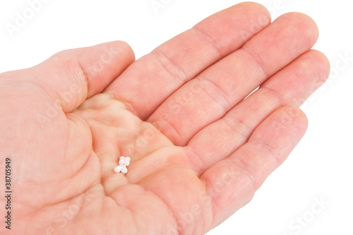 Homöopathische Kügelchen in der Hand