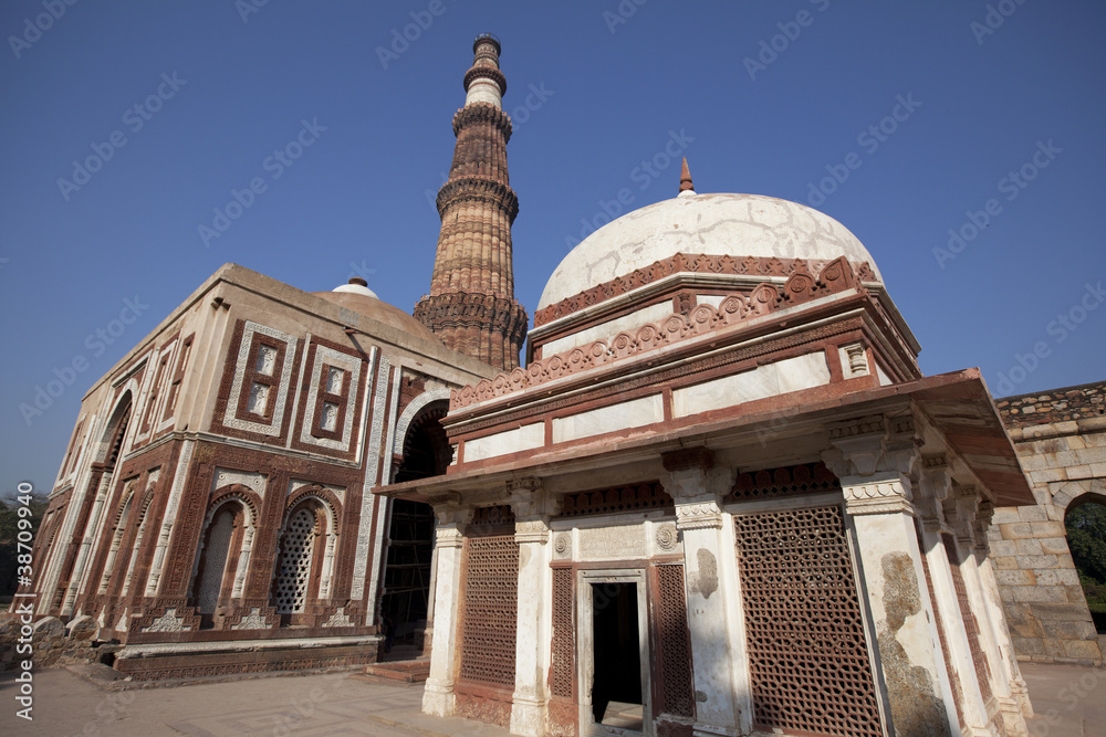Fototapeta premium Indian temple with a tomb and Qutub minar tower at the back