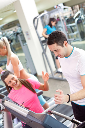 personal trainer encouraging man using treadmill