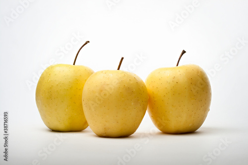 Three yellow apples on white