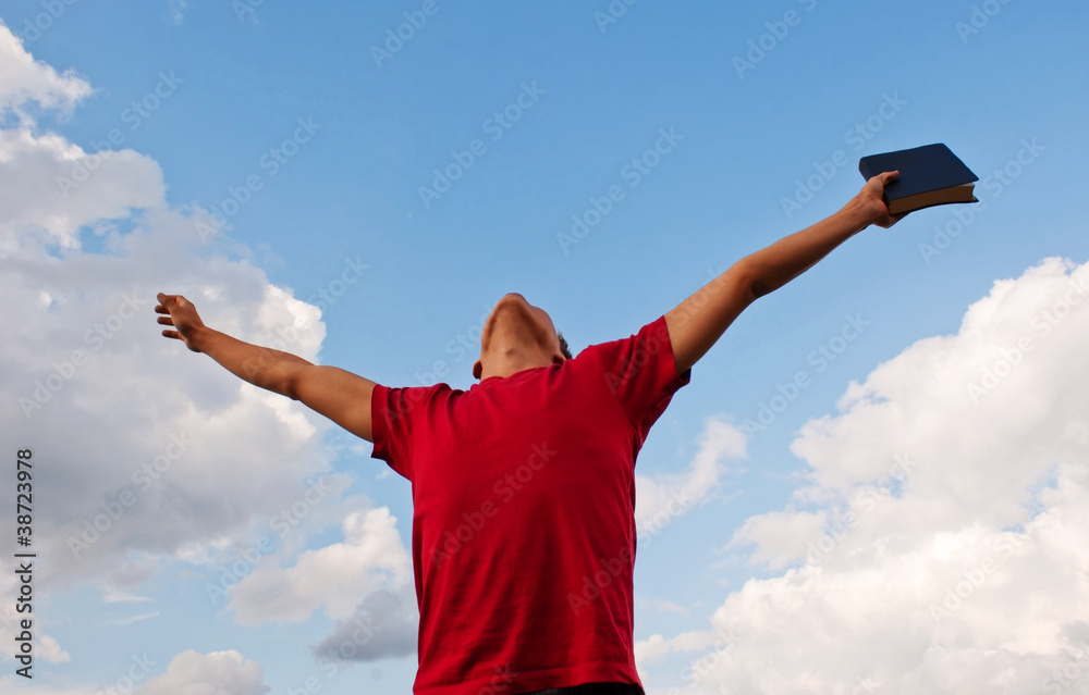 Young man staying with raised hands