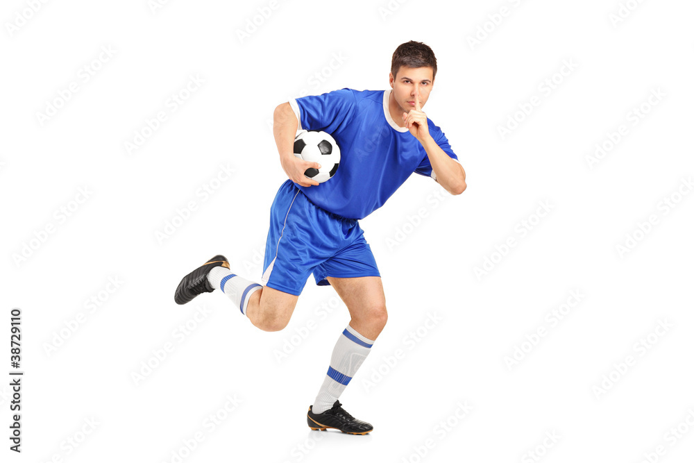 A soccer player running and gesturing silence